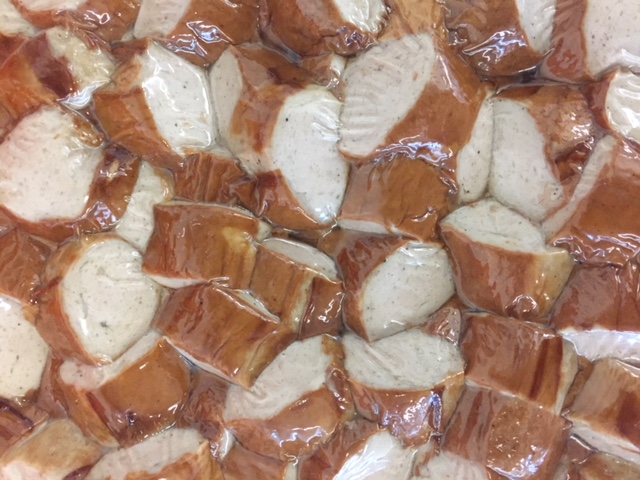 Gebratene, geschnittene Bratwurst in einer Folienverpackung.